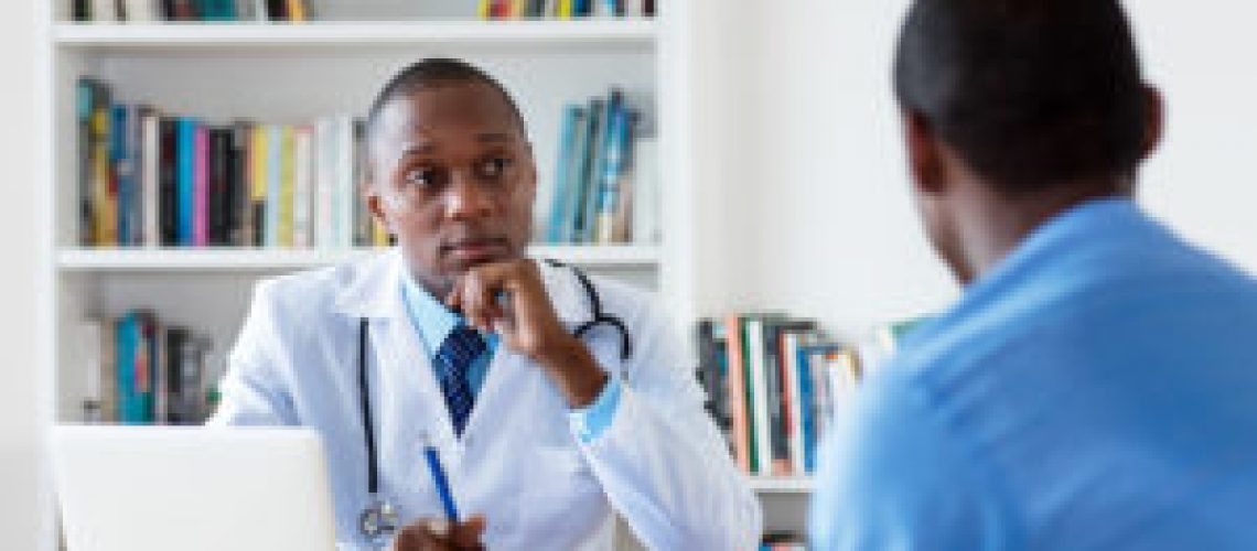 African american doctor with male patient at hospital